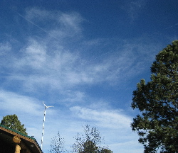 wind turbine with airplane tracks in sky